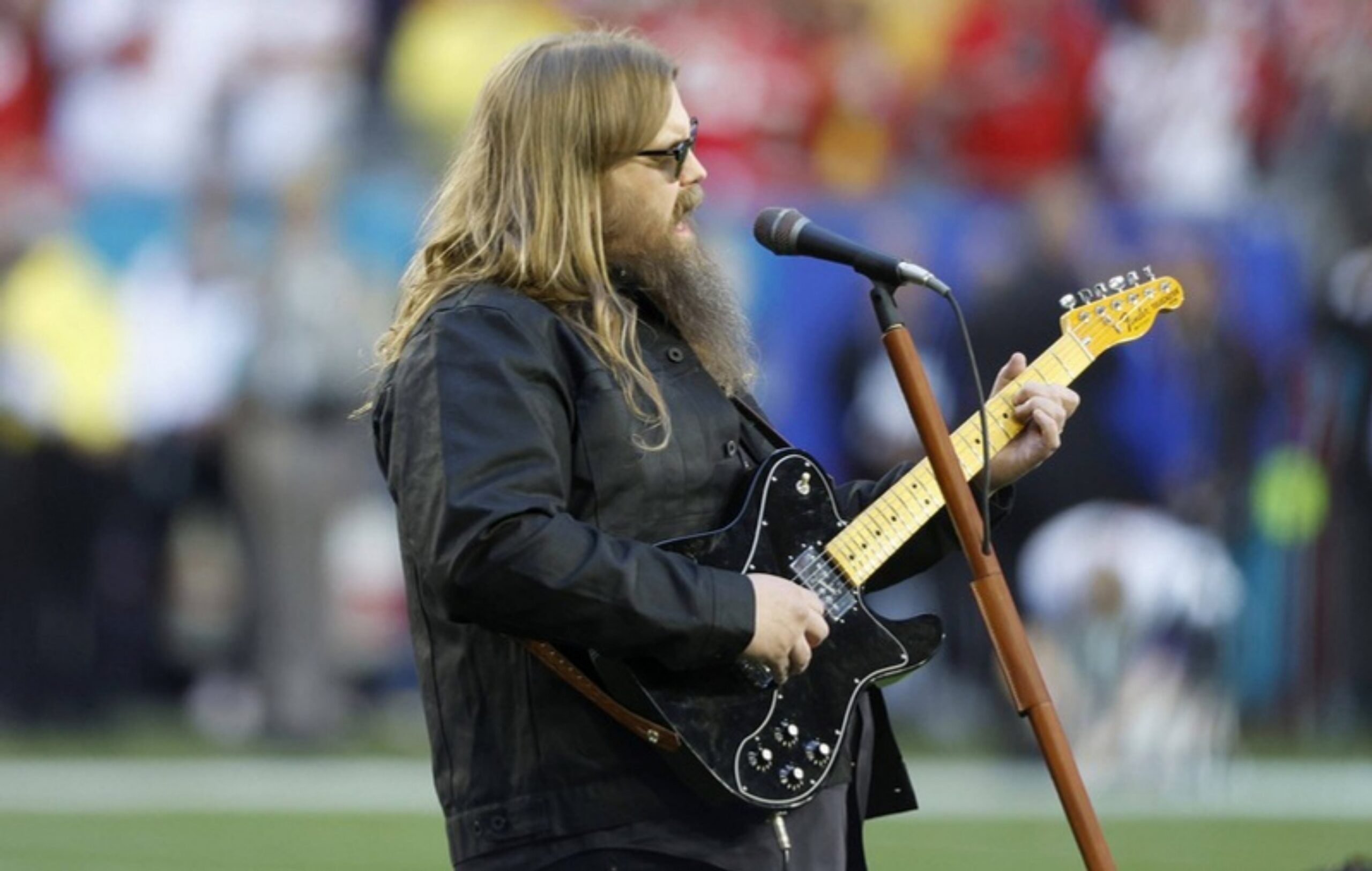 Chris Stapleton singt mit E-Gitarre die Nationalhymne auf dem Rasen beim Super Bowl LVII