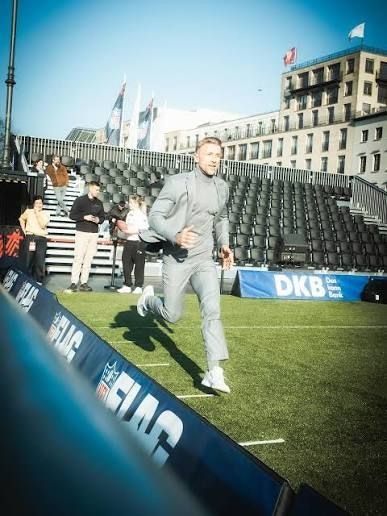 Flo Ambrosius sprintet bei einem NFL-FLAG-Event mit DKB-Bande im Hintergrund