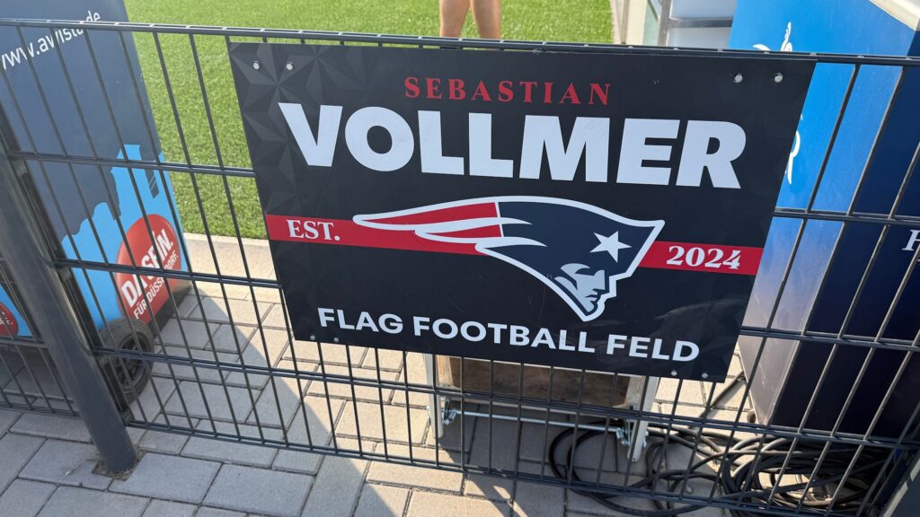 Schild „Sebastian Vollmer Flag Football Feld“ mit Patriots-Logo bei der Flag-Football-WM 2026 in Düsseldorf