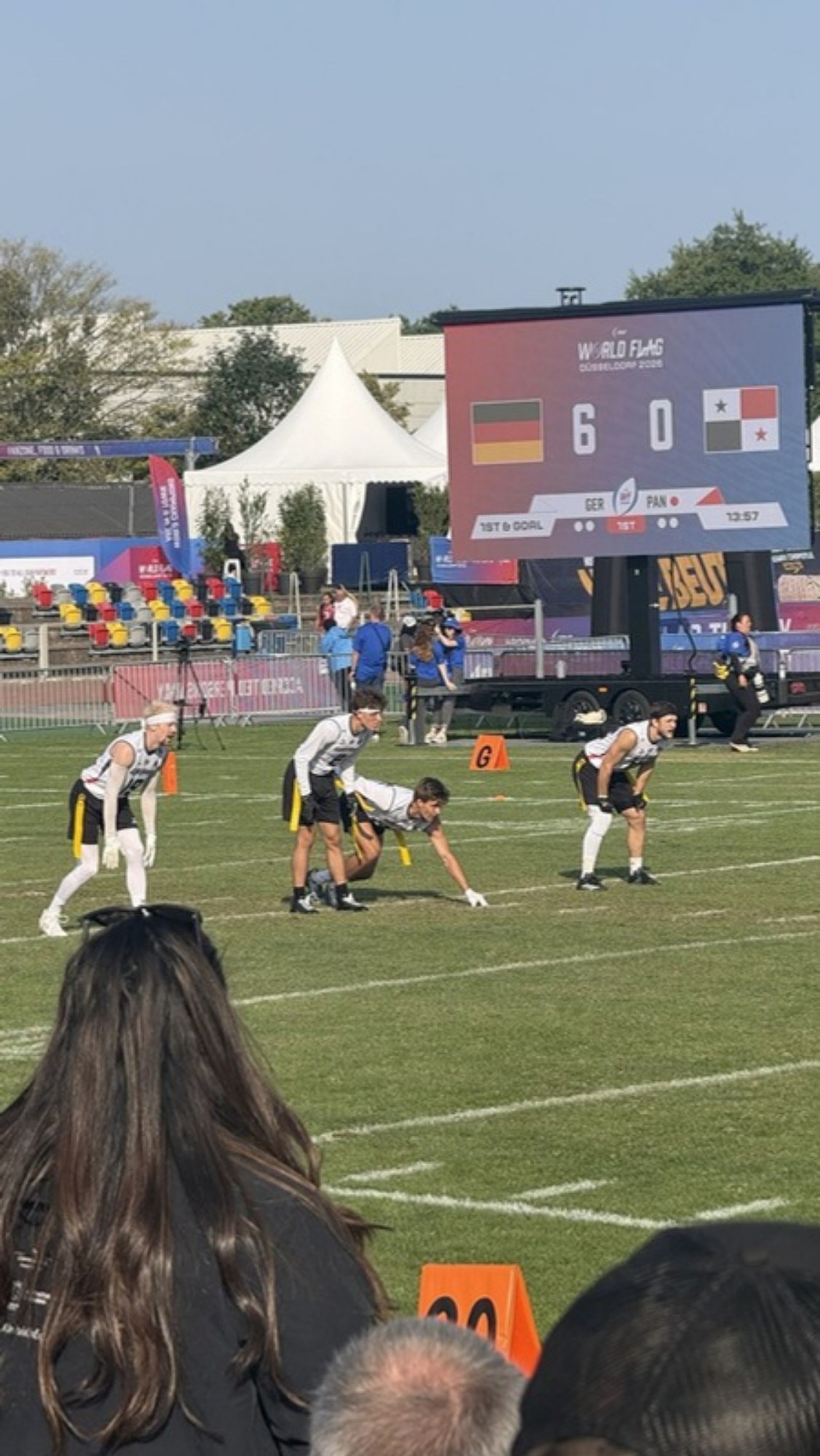 Deutsches Herrenteam an der Line of Scrimmage vor der Anzeigetafel der Flag-WM 2026 in Düsseldorf mit dem Spielstand Deutschland 6, Panama 0