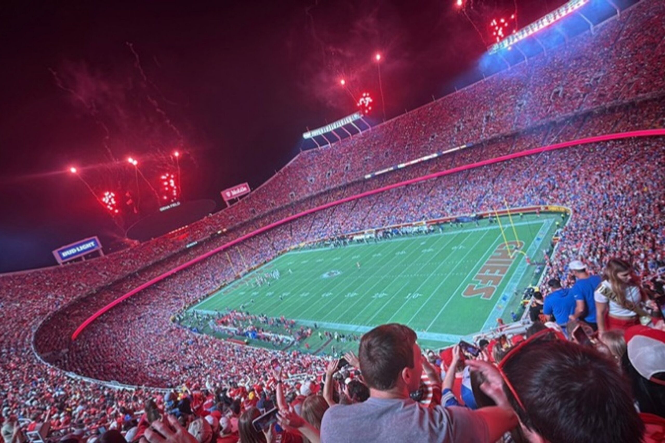 Arrowhead Stadium in Kansas City bei Nacht mit Feuerwerk und Fans in Rot