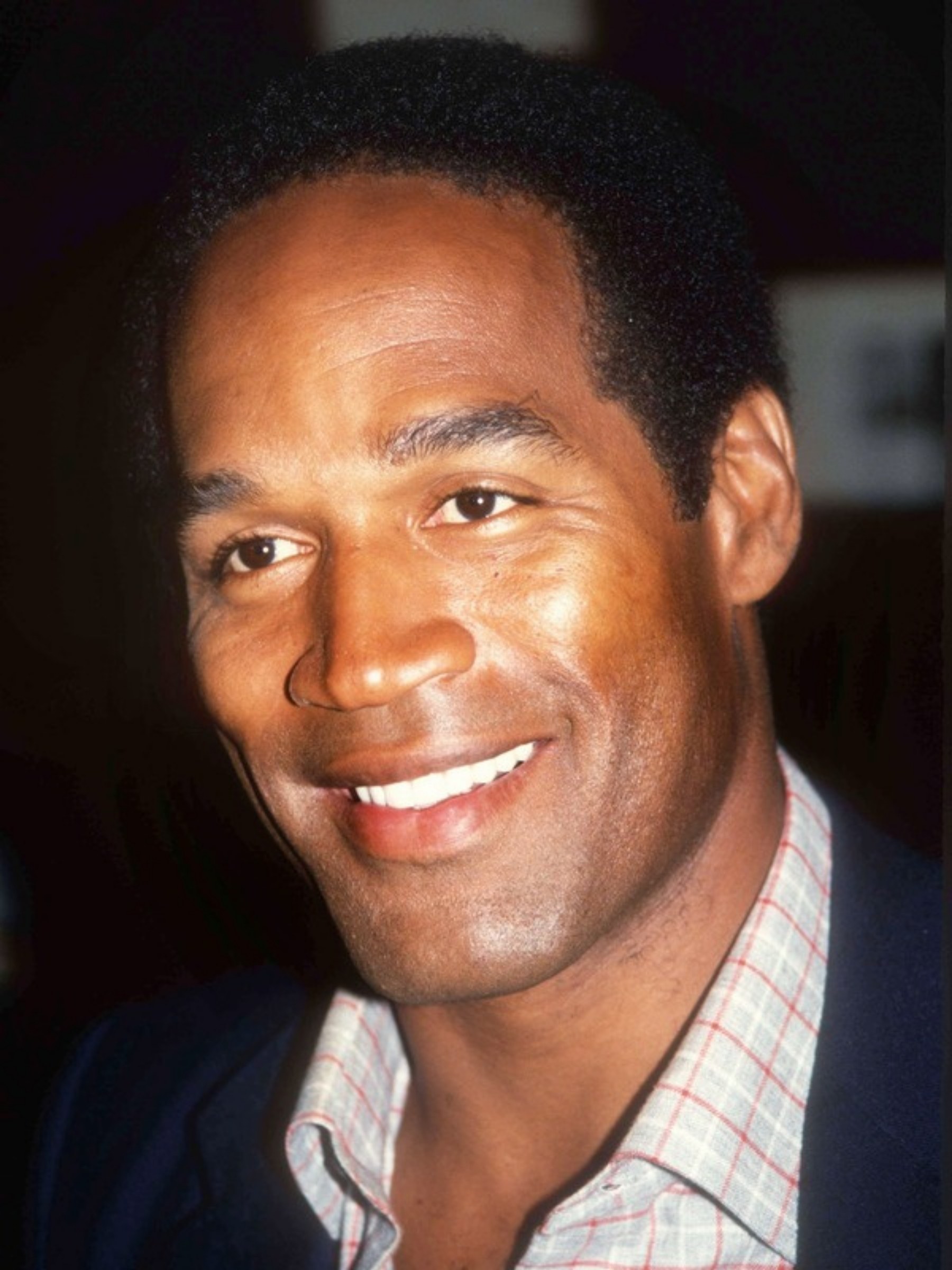 Lächelndes Porträt von O.J. Simpson in Sakko und kariertem Hemd