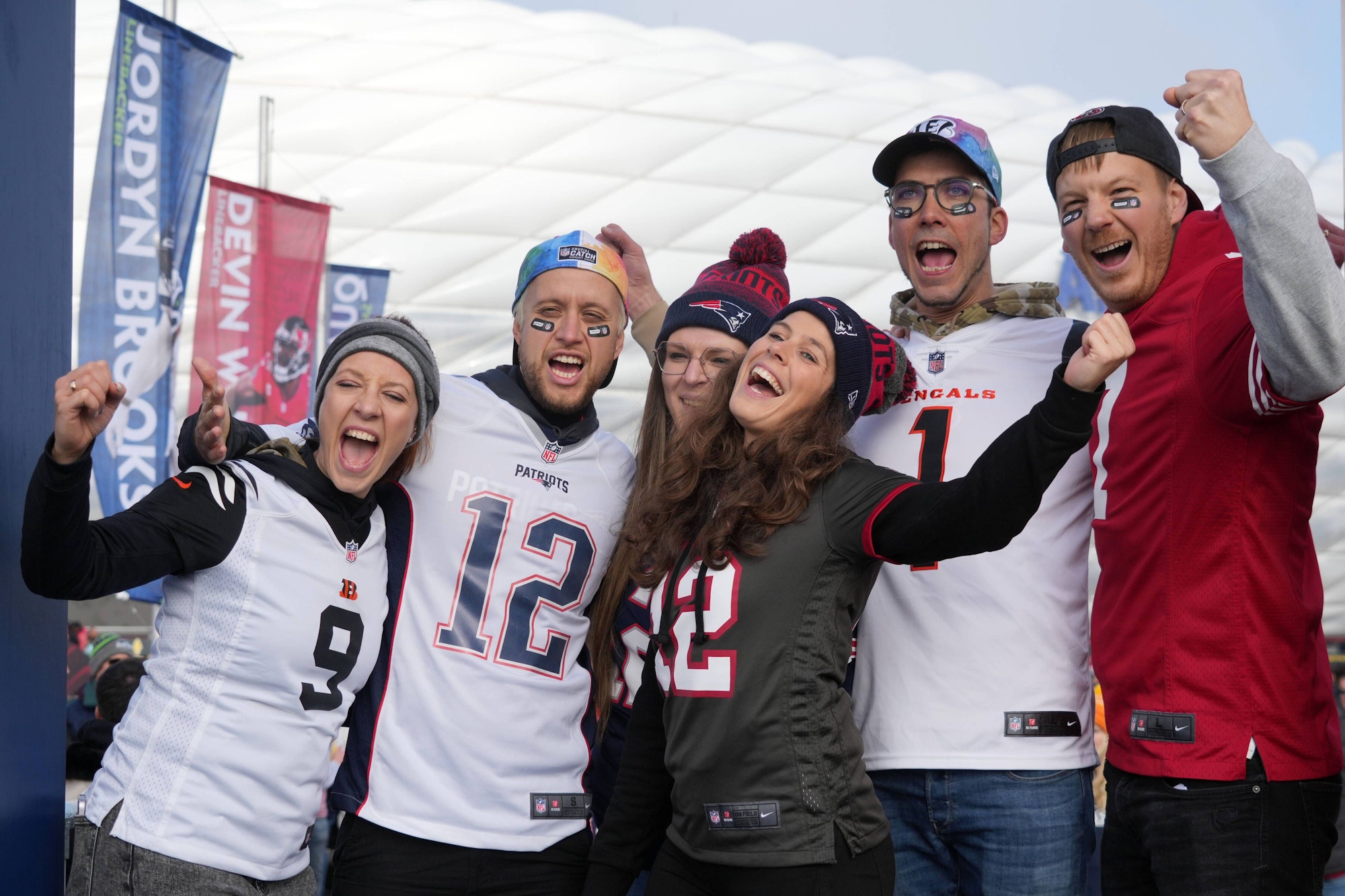 Fans in Trikots verschiedener NFL-Teams jubeln vor der Allianz Arena