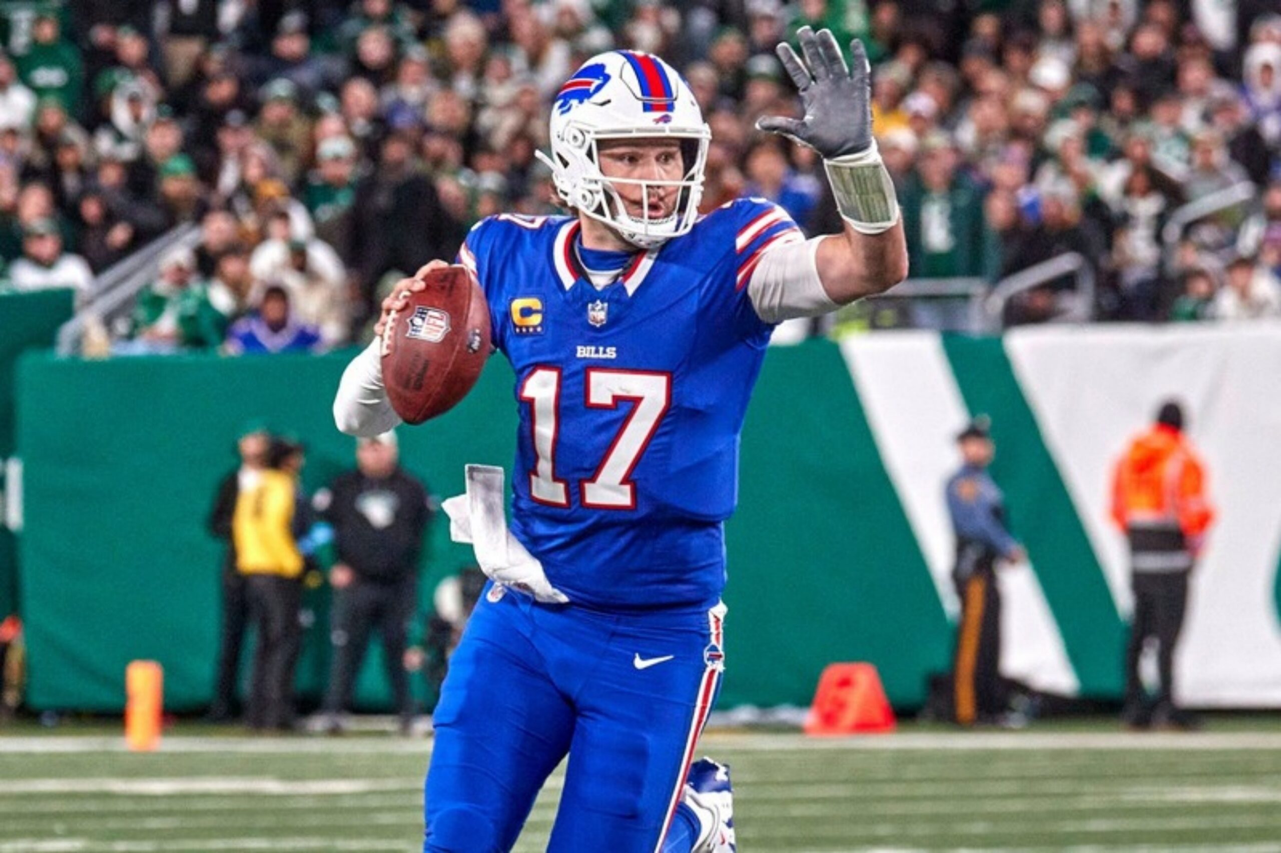 Bills-Quarterback Josh Allen rollt mit dem Ball zur Seite aus und gibt mit der linken Hand ein Zeichen