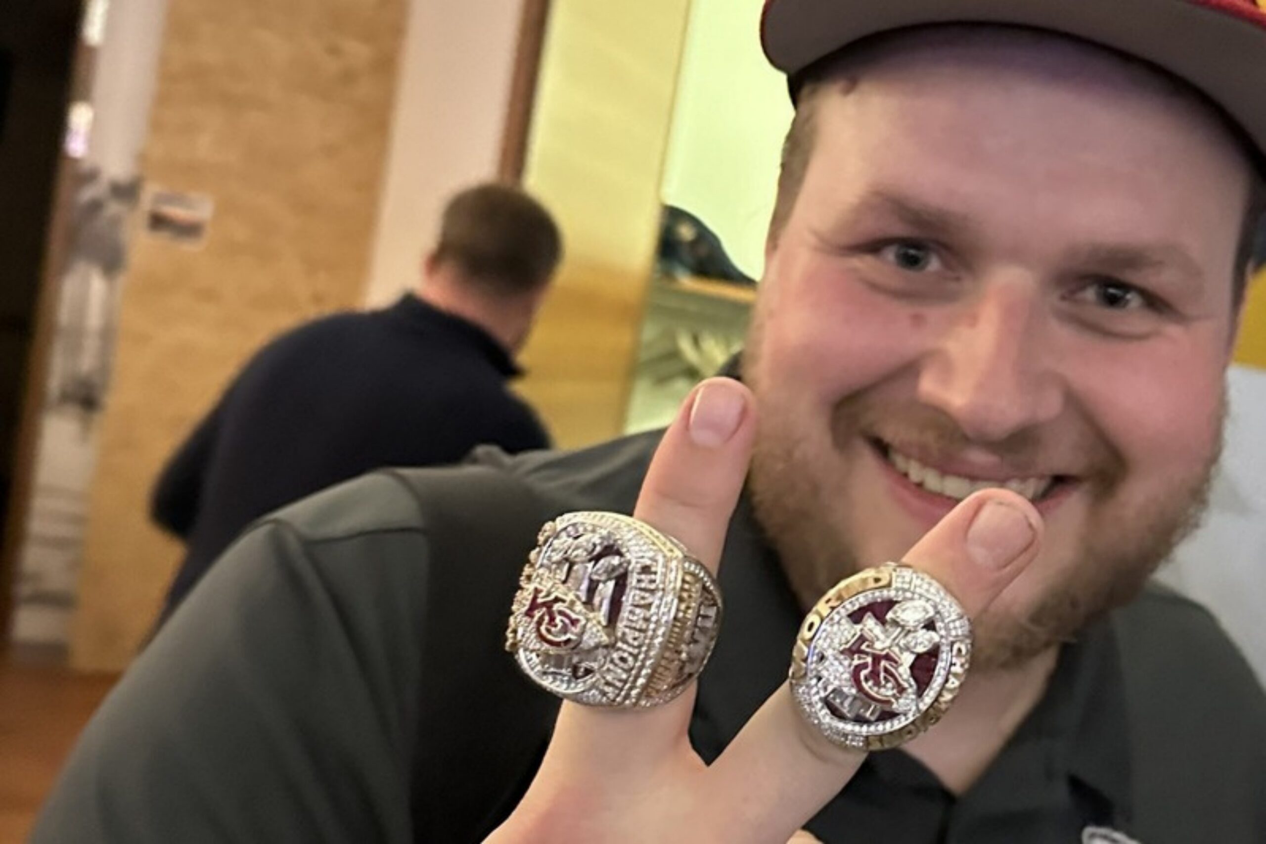 Ein Mann im Chiefs-Outfit trägt zwei Super-Bowl-Ringe der Kansas City Chiefs an den Fingern