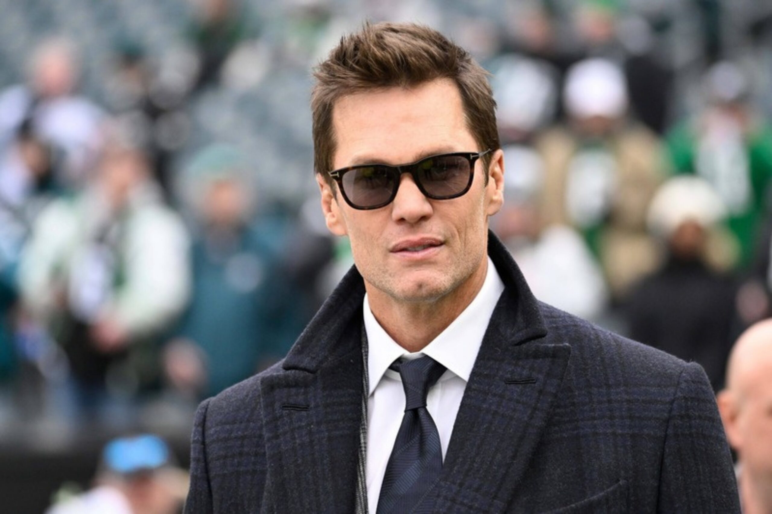 Tom Brady im Mantel mit Sonnenbrille vor einem NFL-Spiel in Philadelphia