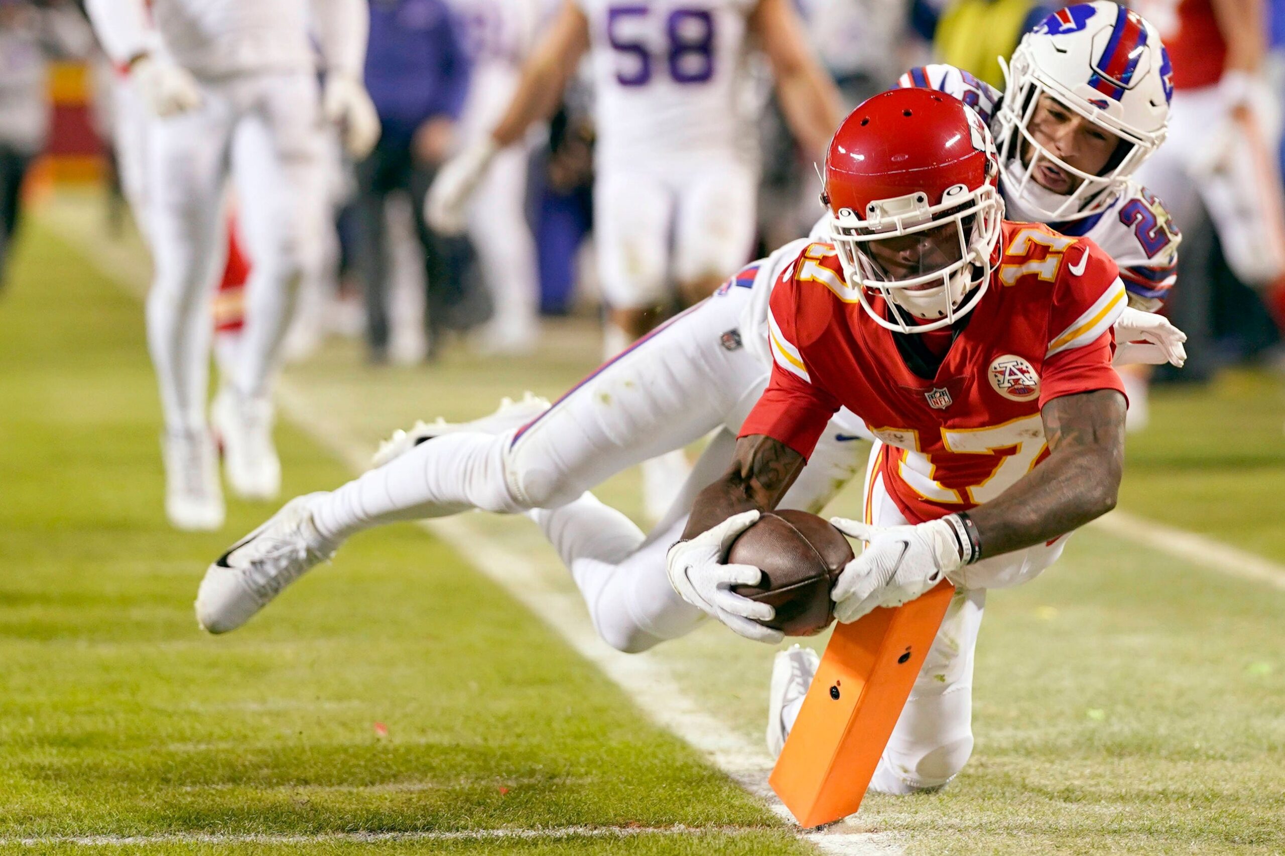 Spieler der Kansas City Chiefs hechtet mit dem Ball an der Pylone über die Goal Line, verfolgt von einem Bills-Verteidiger